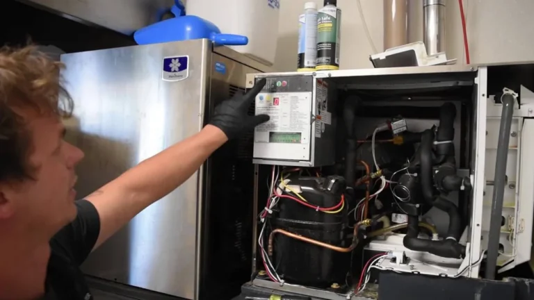 Technician servicing the control panel of a commercial ice machine